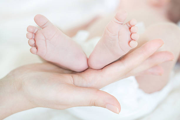 istock Baby feet on hand we have 179222286