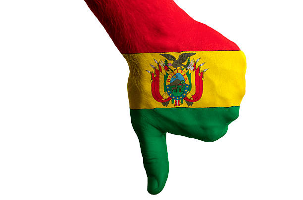 Hand with thumb down gesture in colored bolivia national flag as symbol of negative political, cultural, social management of country