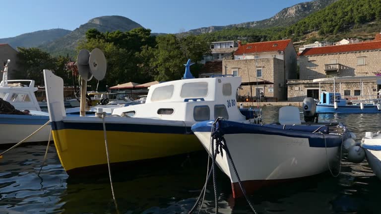 Traditional fishing boats docked in harbor in seaside village, Bol, Croatia