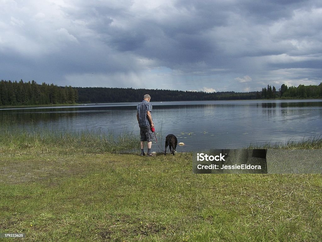 Thristy dog at lake with master Not fishing today, just enjoying being at the lake. Williams Lake Stock Photo