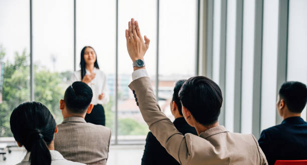 istock Active participation in a conference seminar classroom, with a large group raising hands. The answers lie within the engaged audience, signifying collaborative learning. 1792243817