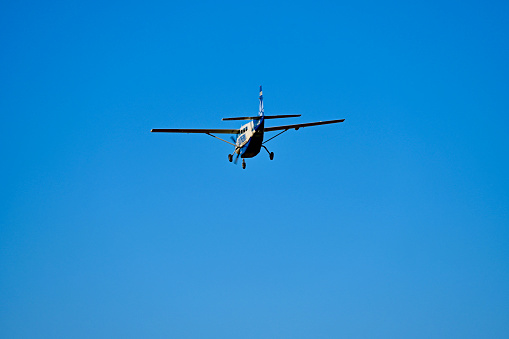 Single engine ultralight plane flying in the blue sky with white clouds