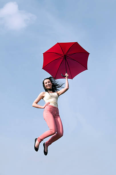 istock woman jumping with red umbrella 179224475