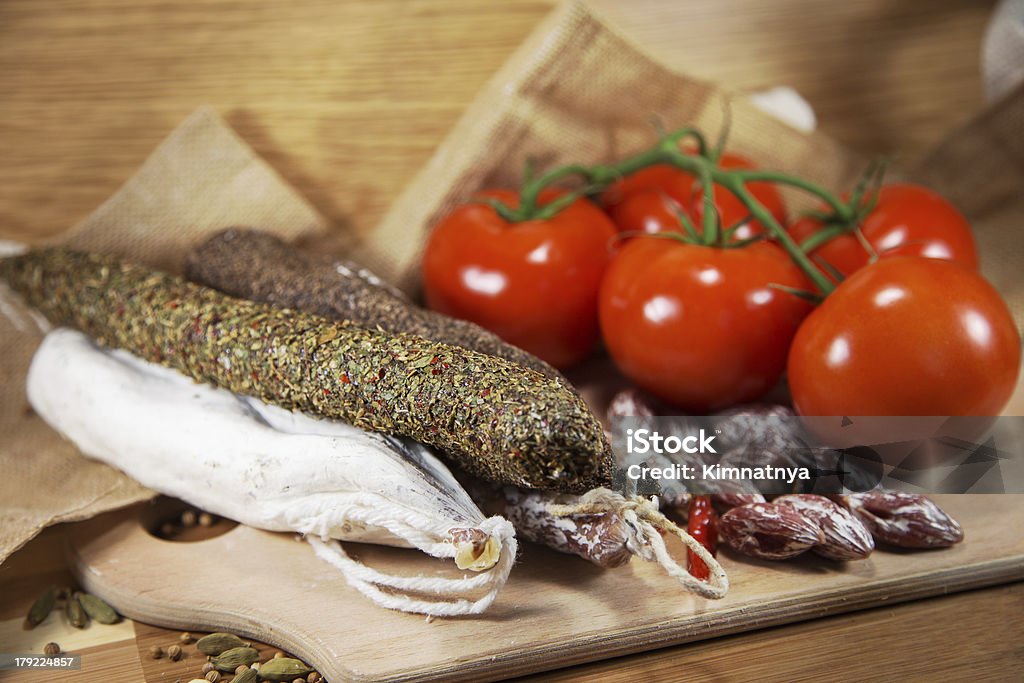 Salami assorted with tomatoes Salami assorted with tomatoes on wood Antipasto Stock Photo