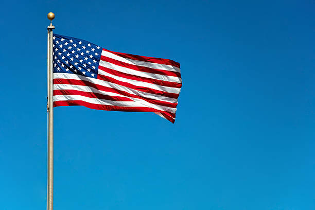 Nosotros bandera estadounidense Saludar con la mano en el viento - foto de stock