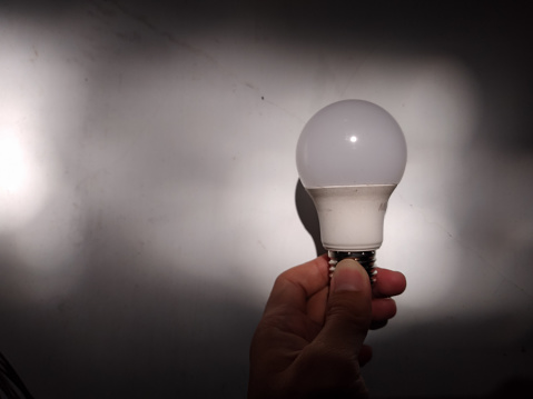 Hand holding Lightbulb in the dark