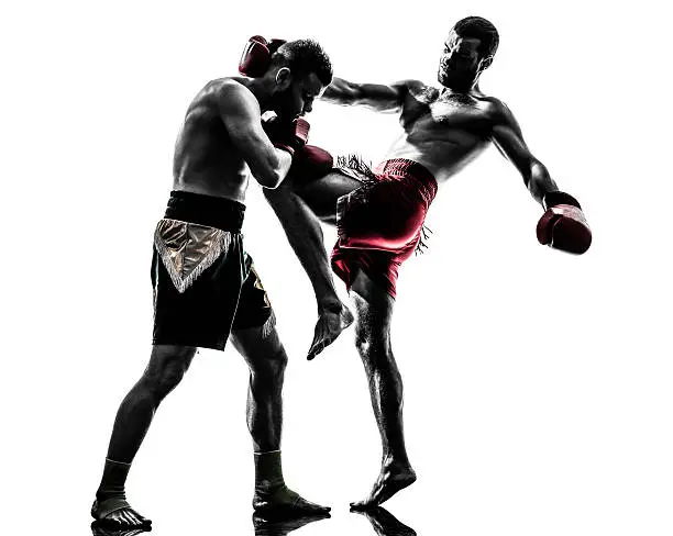 two caucasian  men exercising thai boxing in silhouette studio  on white background