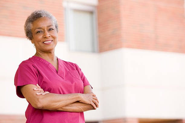 istock Happy nurse in pink standing outside with arms folded 179228782