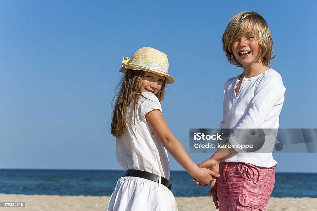 Cute boy and girl holding hands. Portrait of Cute boy and girl holding hands on beach. Boys Stock Photo