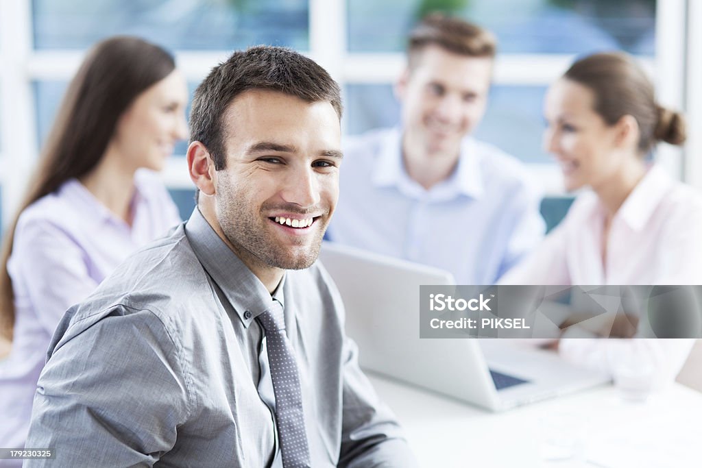 Businessman with coworkers in background Adult Stock Photo