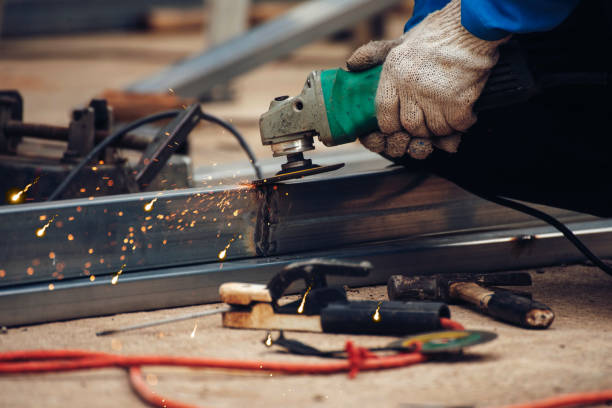 istock Construction Worker hands using Welding machinery iron metal sparking. Men hands wear protective glove Hot flame metal work cutting fire iron workshop. Locksmith use Welding machine cut metal process 1792312119