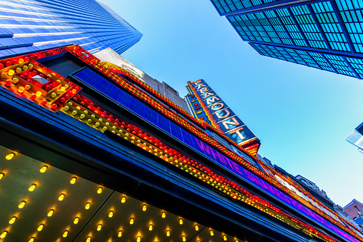 Boston, Massachusetts, USA - November 11, 2023: Skyward view of the colorful marquee of the Paramount Theatre. The theatre is in downtown Boston on Washington Street, between Avery and West Streets. The Paramount opened in 1932 as a 1,700-seat, single-screen movie theatre. It was one of the first movie houses in Boston to play talking motion pictures. The theatre was named after its original owner, Paramount Pictures. In 1984, the building was designated a Boston Landmark by the Boston Landmarks Commission.