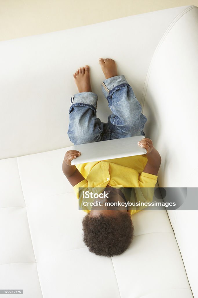 Vista de cima de garoto no sofá brincando com Tablet Digital - Foto de stock de 12-17 meses royalty-free