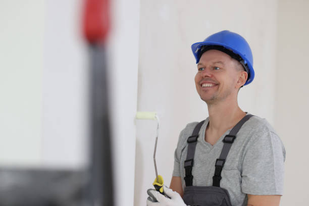 istock Happy man builder with a roller against the wall, close -up 1792330582