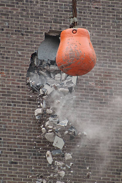 istock Orange wrecking ball smashing through brick on building 179233484