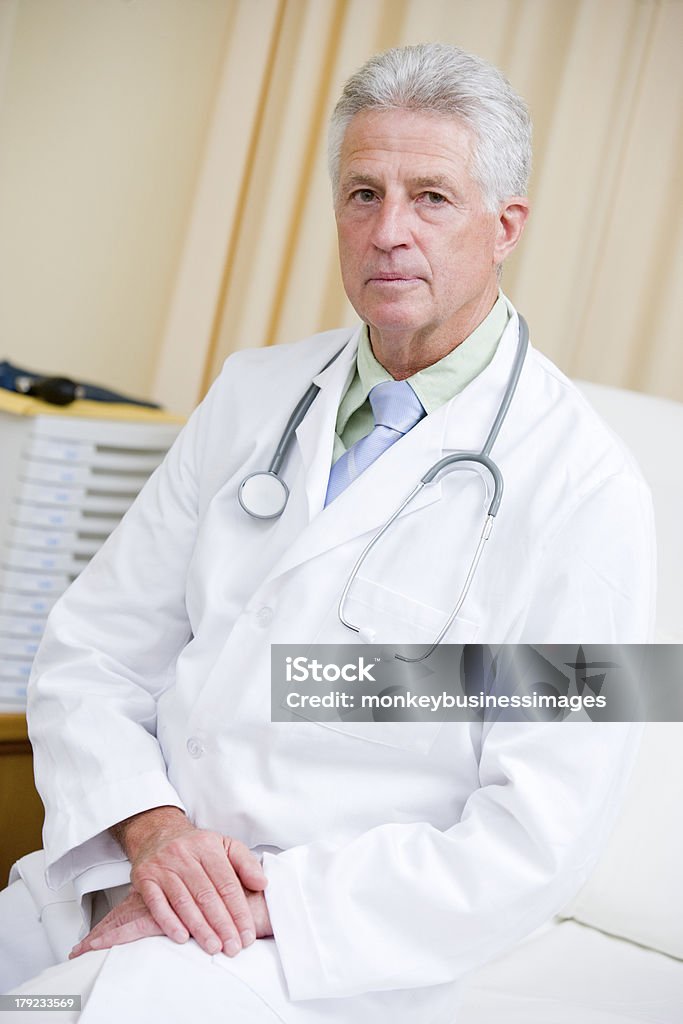 Médico sentado en la cama de Hospital - Foto de stock de 50-59 años libre de derechos