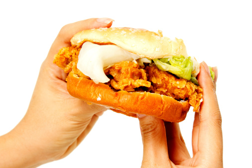 Hand holding a chicken burger