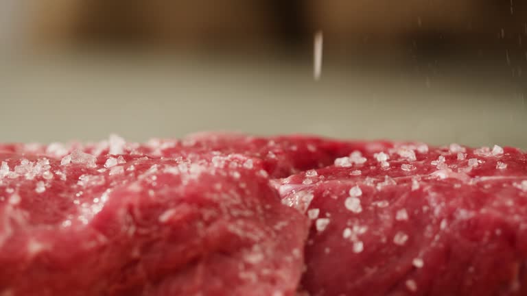 Man chef sault pickle beef steake meat on wooden desk close-up macro. Professional cheif preparing meat in restaurant kitchen. Delicious barbecue pork, spicy cuisine, american barbeque.