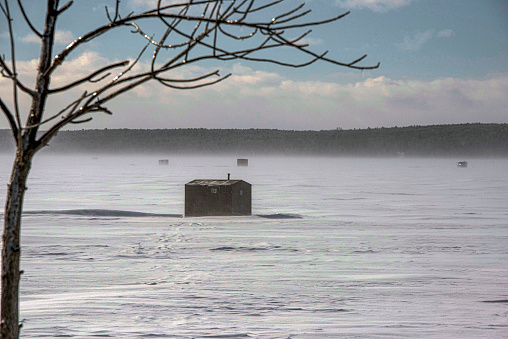 An ice-fishing shack on a cold, windy day. The shacks sit on several feet of ice on Green Bay, an arm of Lake Michigan. These shacks, as cold as they may look from the outside, often have heat, cook stoves, furniture, and many other amenities.