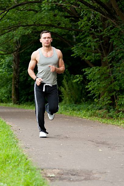 istock Man with black pants run on the road in park 179236059