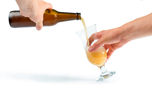 Hand holding bottle of beer and mug