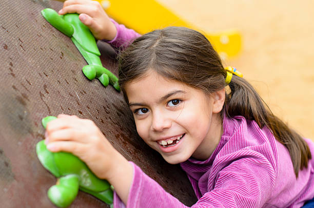 Little girl on a climbing wall in a park