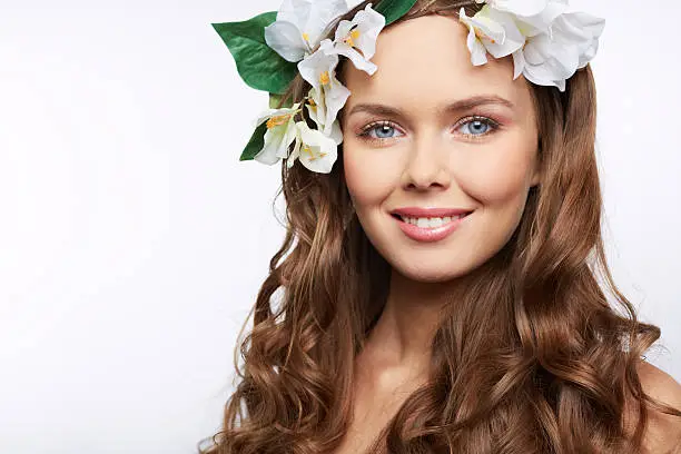 Close-up portrait of a young female with white floral wreath on head