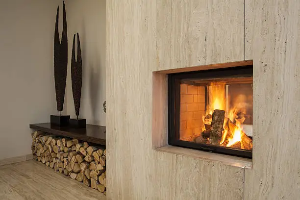 Travertine house: Burning fireplace and pieces of wood