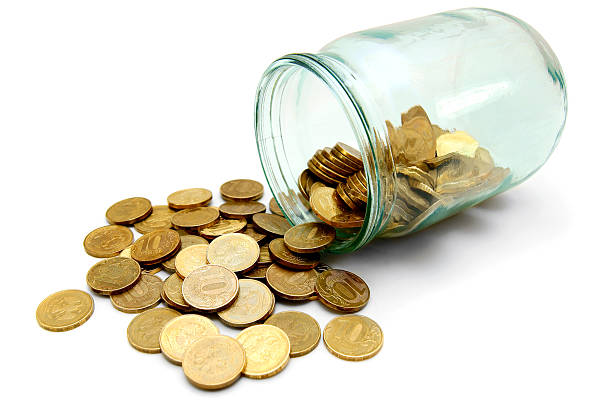 istock glass with gold coins. On white background. 179240294
