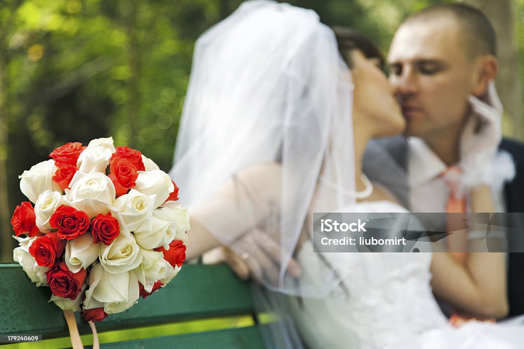 Букет с размытым Целовать жениха и невесты - Стоковые фото Белый роялти-фри