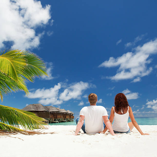 casal feliz sentado na sunny beach - women hawaii islands beach beauty in nature imagens e fotografias de stock