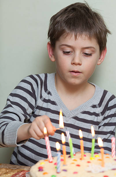 istock Little boy lights candles on cake 179243139