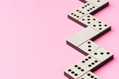 Domino tiles on pink background studio shot close up