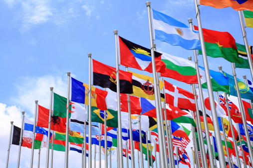 A 3d rendering of national flags in the global communication, messaging, and translation concept with a hand reaching