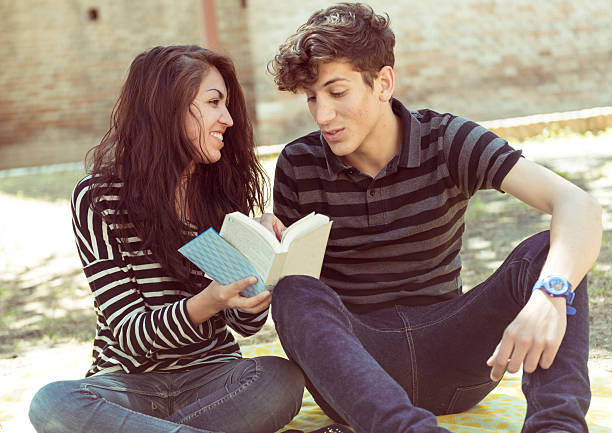 istock young couple reading book in park 179244192