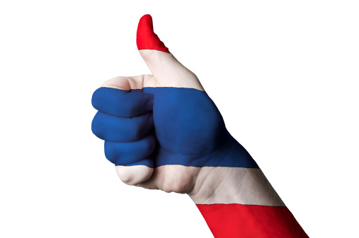 Hand with thumb up gesture in colored thailand national flag as symbol of excellence, achievement, good, - for tourism and touristic advertising, positive political, cultural, social management of country