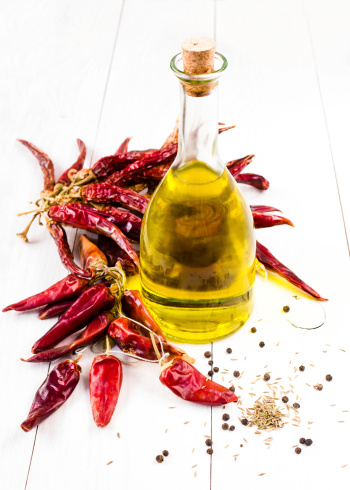 Olive oil bottle and Red hot chili pepper on white