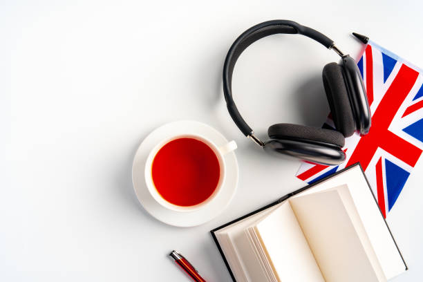istock Notepad with British flag and headphones on white background. English language audio courses educational concept 1792473957
