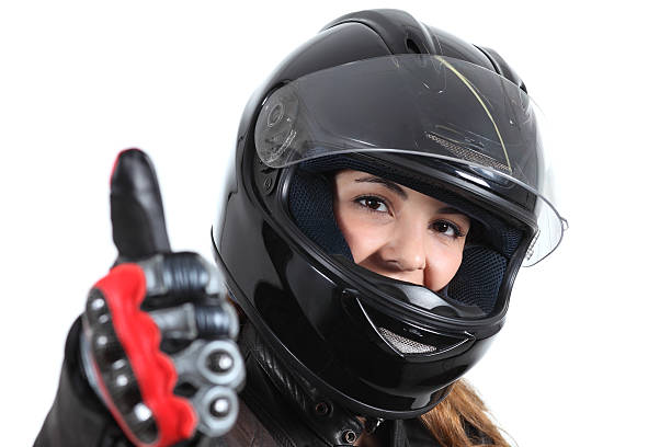 mujer feliz ciclismo de calle con un casco y botón pulgar levantado - motorcycle women helmet sensuality fotografías e imágenes de stock