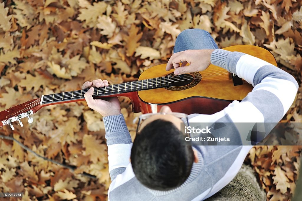 Jovem com guitarra em park - Foto de stock de Abaixo royalty-free