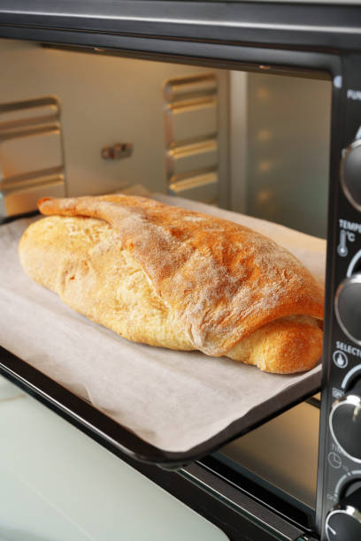 istock Freshly baked bread in mini oven in the kitchen 1792505580