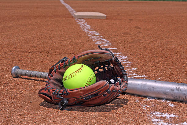 softball glove and bat yellow ball bat and glove on the softball baseball field base sports equipment photos stock pictures, royalty-free photos & images