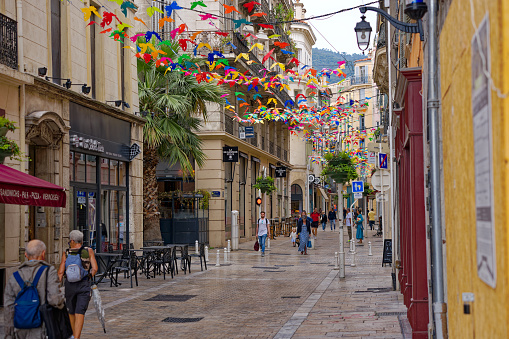 Alley with shops and pedestrians at French City of Toulon on a cloudy late spring day. Photo taken June 9th, 2023, Toulon, France.