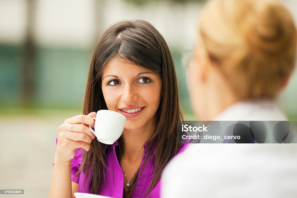 Business women drinking coffee two business women drinking coffee outdoors 20-24 Years Stock Photo