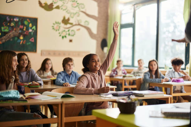 istock Happy black elementary student raising her hand on a class at school. 1792530449
