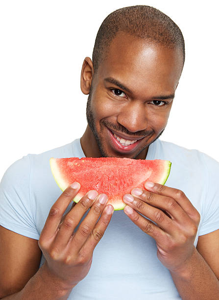 istock Man smiling and eating delicious watermelon 179253528