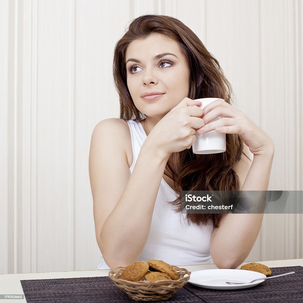 Piękna kobieta picie herbaty i pliki cookie - Zbiór zdjęć royalty-free (Biurko)