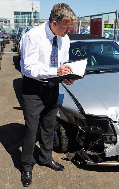 istock A loss adjuster looking at a car involved in an accident 179253739