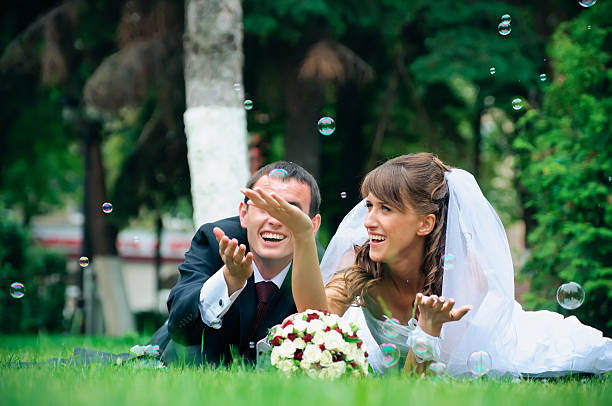 istock groom and bride lie on a grass around soap bubbles 179255806