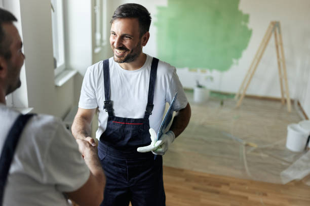 istock Happy house painter shaking hands with his colleague during home renovation process. 1792563231